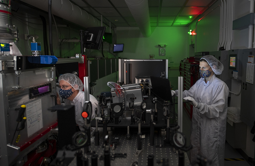 Anthony Gonzalves (left), Staff Scientist, and Marlene Turner, Postdoctoral Scholar, setting up the equipment at the Berkeley Lab Laser Accelerator (BELLA) at Lawrence Berkeley National Laboratory, 05/25/2021, Berkeley, California. (Credit: Thor Swift/Berkeley Lab)