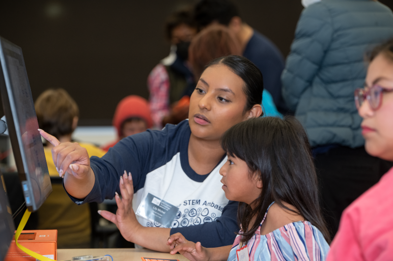 Liliana Michel, Workstation Support Team Lead, explains computer concepts to a student. (Credit: Thor Swift/Berkeley Lab)